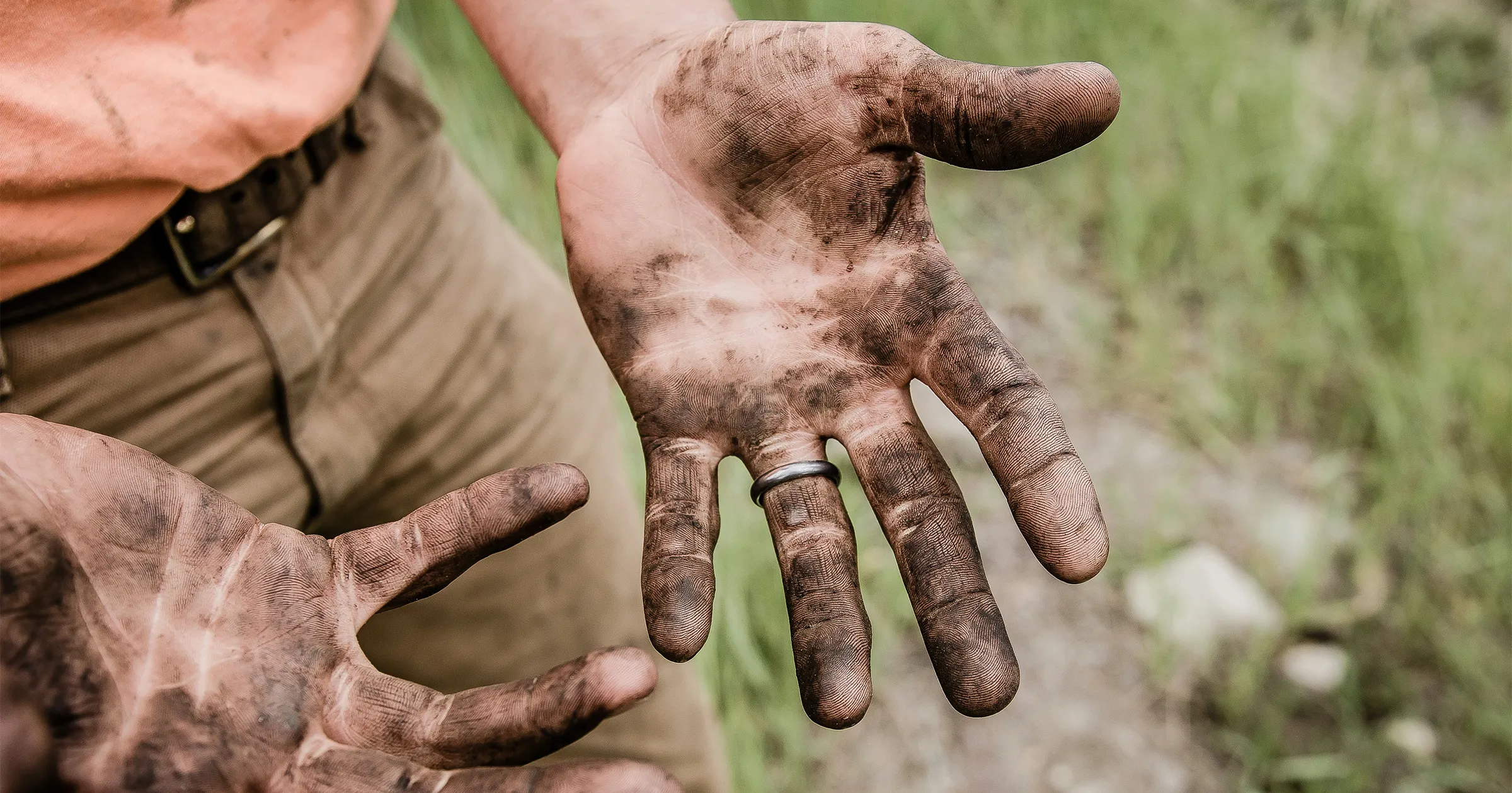 Man working outside with dirt on his hands